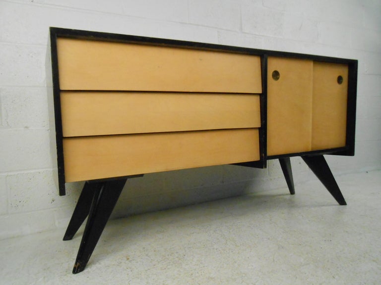 Canadian designer Russell Spanner for Ruspan of Toronto. Designed in 1952 as part of the Catalina Series with it's distinctive splayed legs and overlapping drawers and sliding doors concealing an adjustable shelf. Please confirm item location (NY or