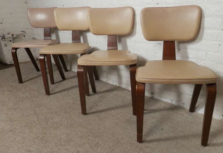 Four vintage chairs by Thonet with classic angled frames. Crafted of bent wood that shows off an lovely sculptural design. The seat and back rest are covered in a cream white vinyl. Once restored these will pop back to life!

(Please confirm item