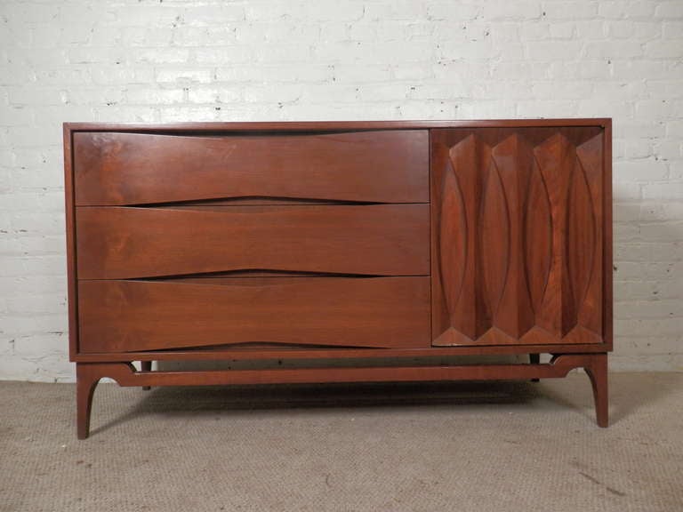 Mid-Century Modern flair added to this very functional low dresser. Arne Vodder inspired deep drawers with diamond front, carved front door and finely tapered legs.

(Please confirm item location - NY or NJ - with dealer).