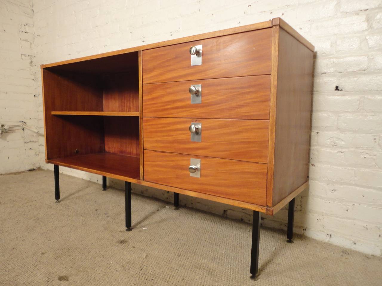 Unusual vintage cabinet in the manner of George Nelson for Herman Miller. Features stunning wood grain drawers with accenting polished chrome hardware, open cabinet with shelf, set on sleek black legs. Great for home or office use.

(Please
