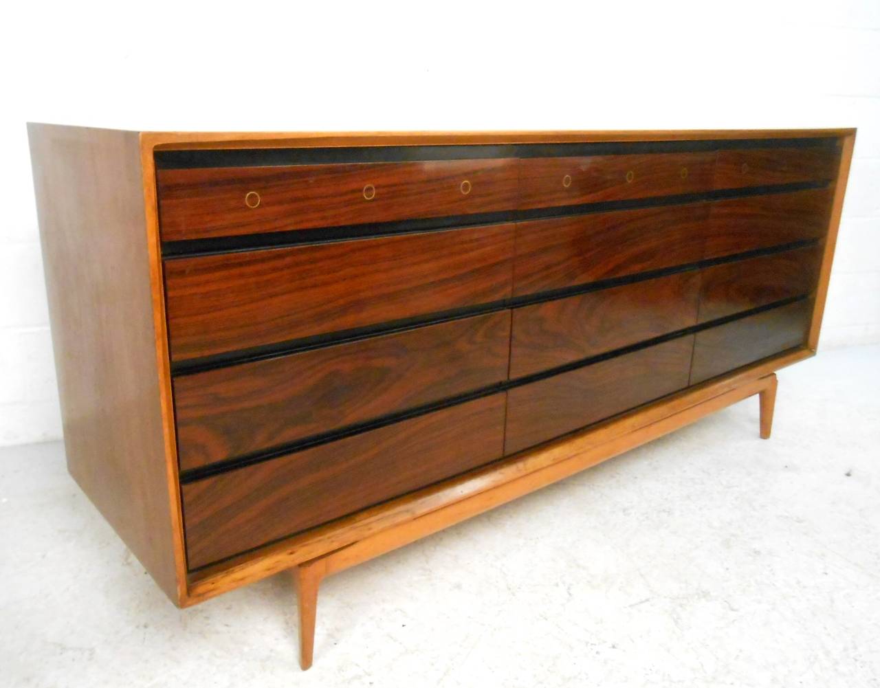 This beautiful mid-century Rosewood dresser was manufactured in Belgium, and offers 12 drawers for plenty of storage. Unique sculpted base pairs beautifully with wonderful top drawer inlays.  Fantastic woodgrain set's this piece above other dressers