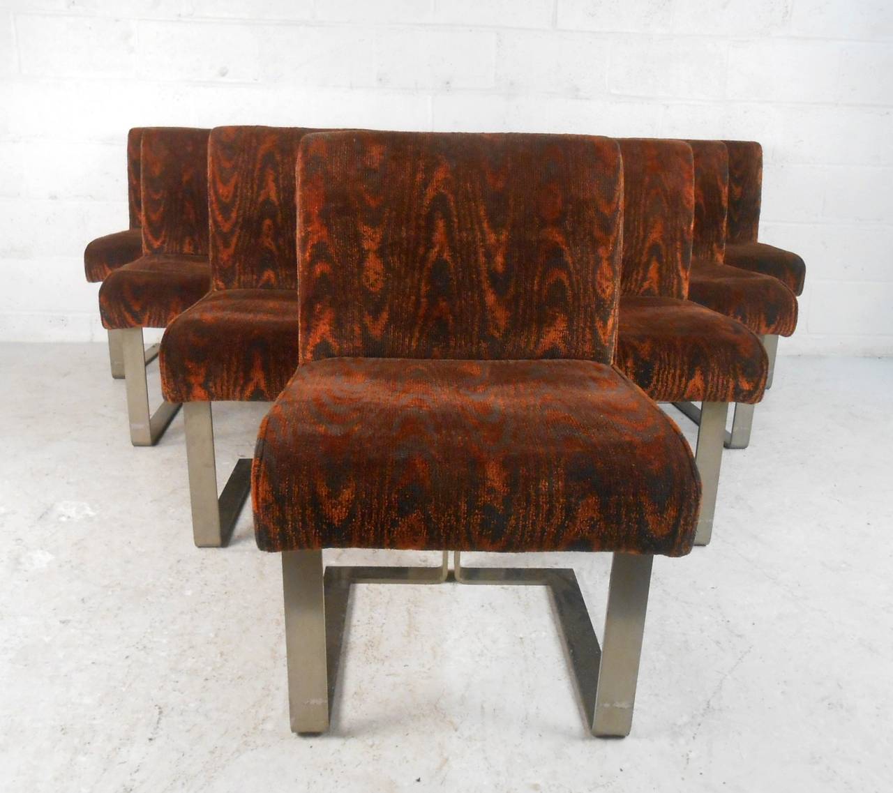 This beautiful and unique set of ten chairs feature remarkable Mid-Century design. Wonderful vintage upholstery covers these comfortable seats framed on substantial metal bases. Rare matching set with animal print upholstery, sturdy and stylish for