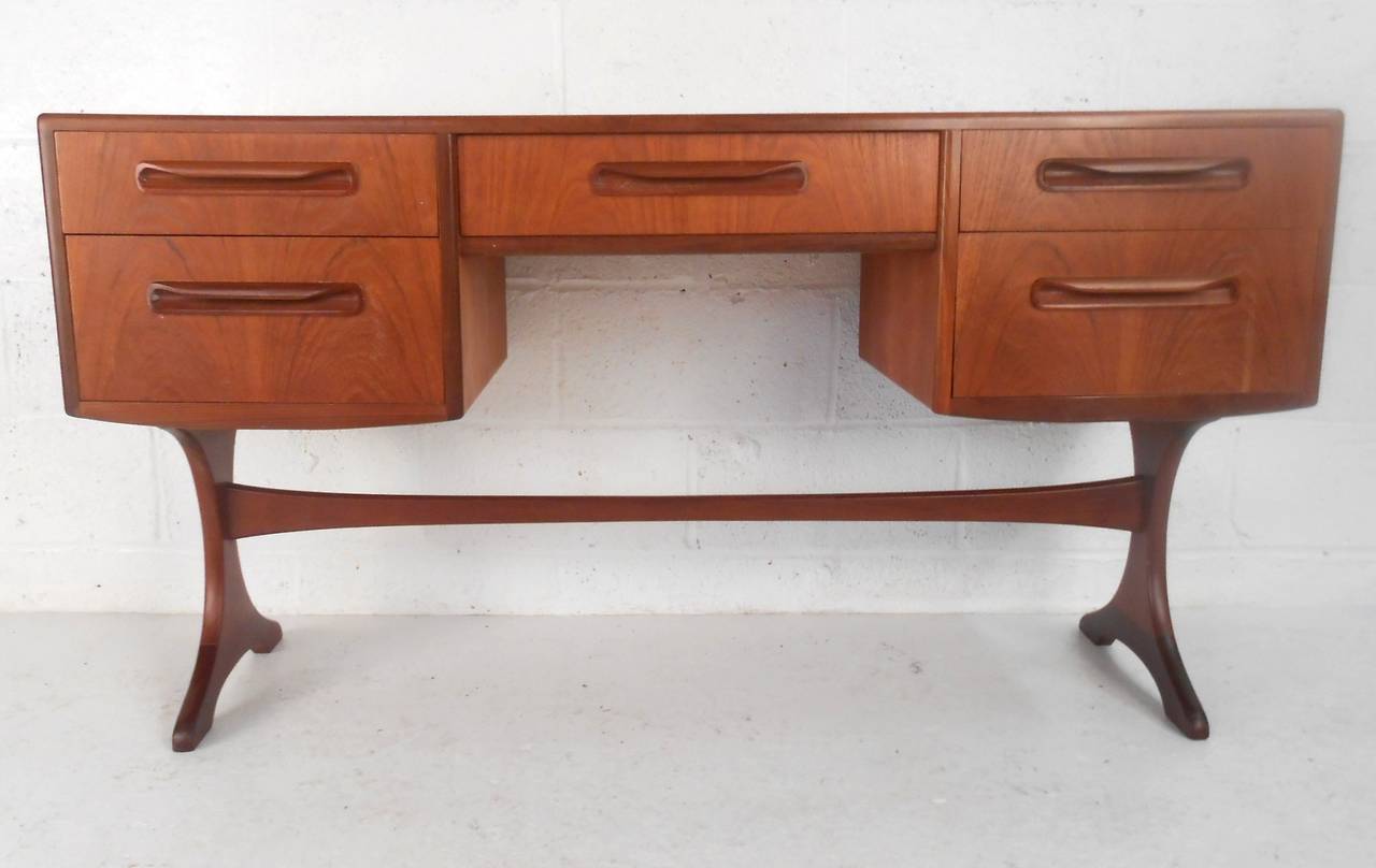 This unique narrow Danish vanity combines beautiful mid-century style with a perfect apartment sized footprint. Carved handles and velvet lined top drawer accentuate the beauty of it's vintage teak finish. Please confirm item location (NY or NJ).