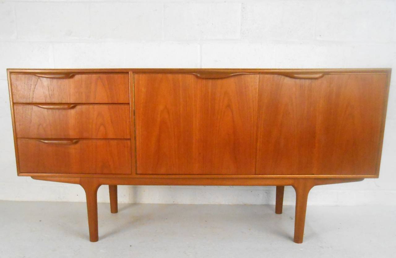 This beautiful teak sideboard combines a wonderful vintage finish with unique sculpted handles. Manufactured by A.H. McIntosh & Co. this piece offers a unique miniature footprint, well suited for apartments and other layouts where space is at a