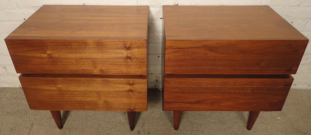 Pair of vintage modern bedside tables with two drawers. Sleek symmetrical design with beautiful walnut wood grain. Solid construction, modern lines, tapered cone legs.

(Please confirm item location - NY or NJ - with dealer)