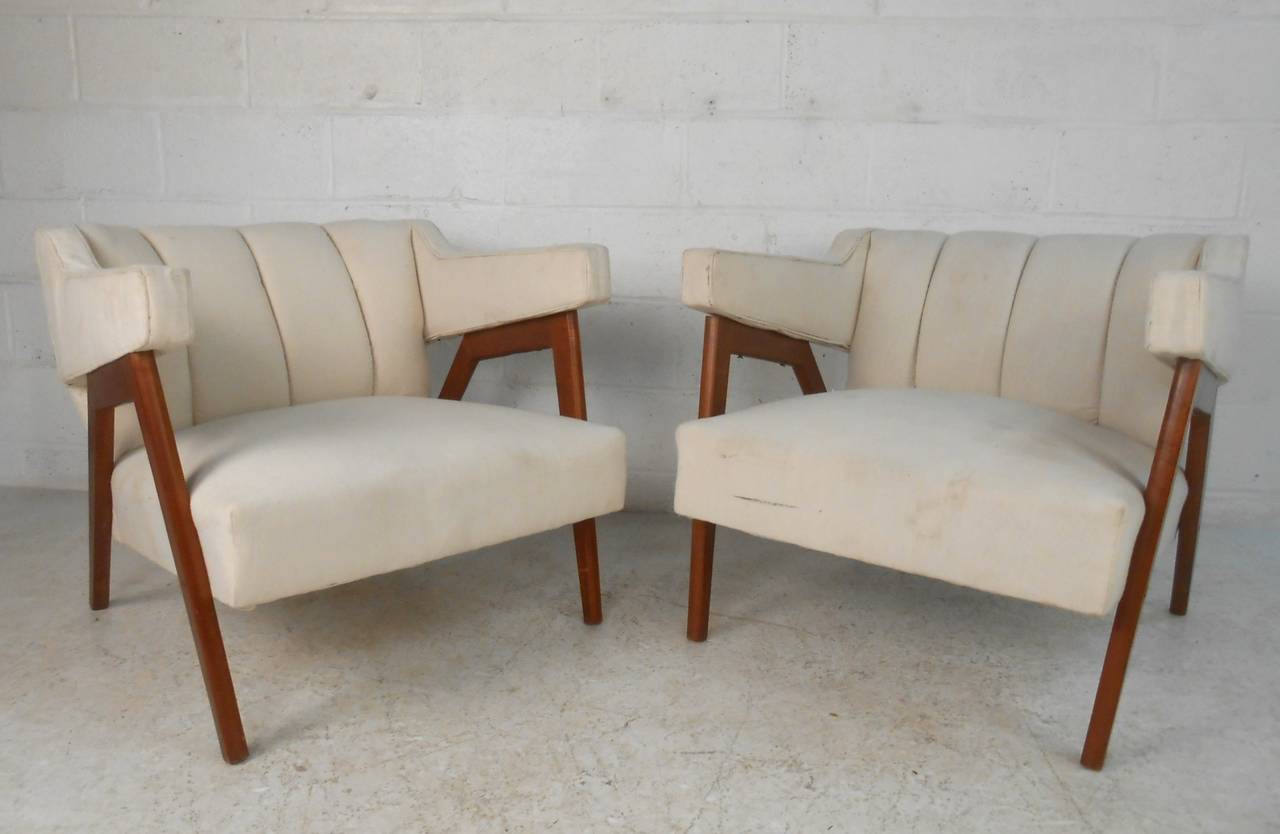 Wonderfully sculpted walnut frame combined with comfortable seat backs and armrest design sets this matching pair of vintage club chairs apart from other seating options. Perfect addition of style and comfort for any interior; please confirm item