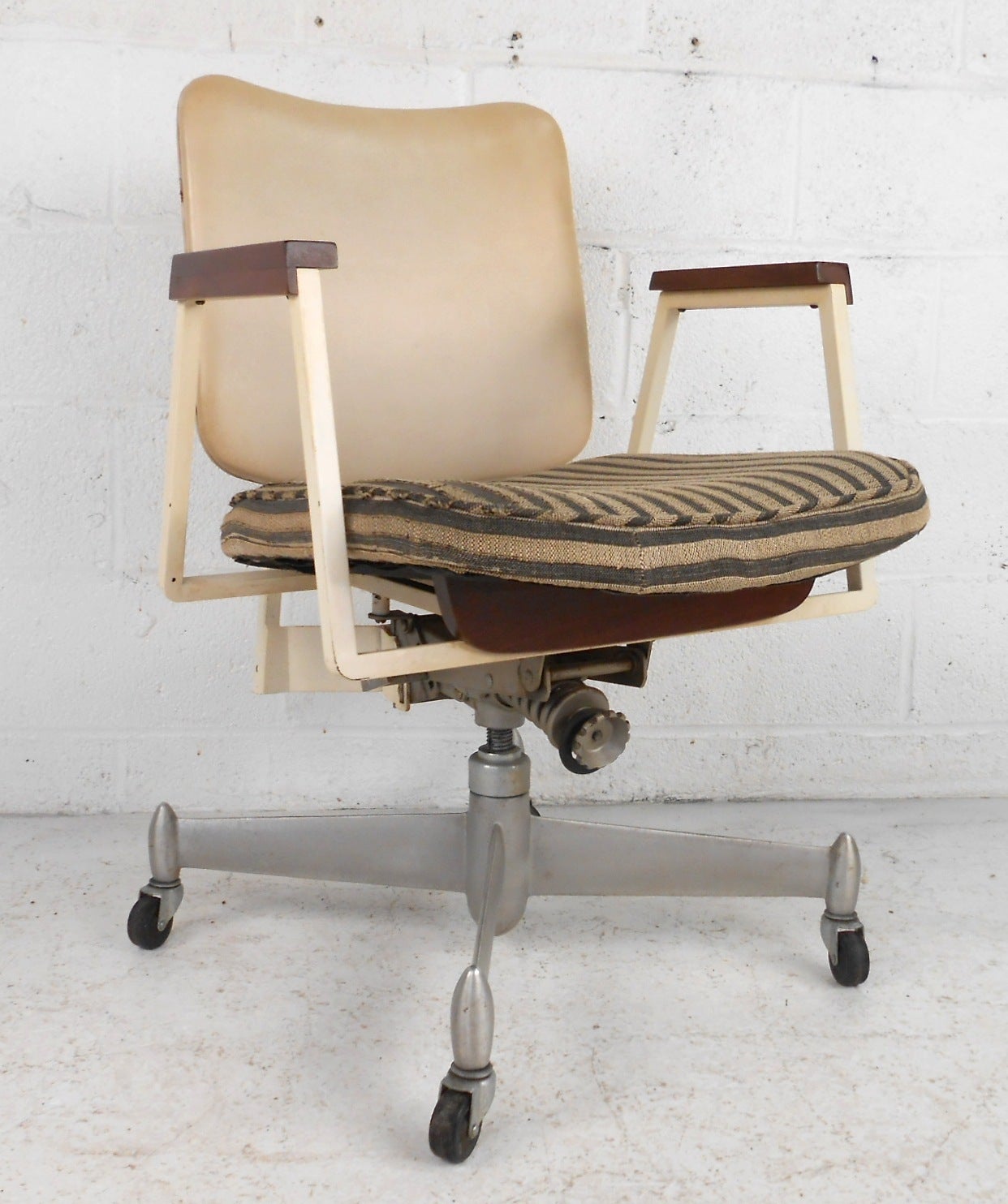 Very unusual office chair on casters with walnut trimmings. Cream colored seat back and matching metal frame set on a sturdy swivel base with casters. Nice detailing throughout.

(Please confirm item location - NY or NJ - with dealer)