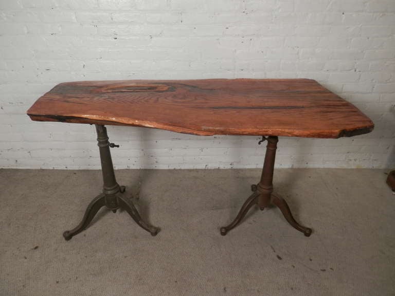 One of a kind table with a thick tree slab top set upon two heavy fully adjustable iron bases. Height and angle can be adjusted. 
Used as a writing desk or console table.

(Please confirm item location - NY or NJ - with dealer).