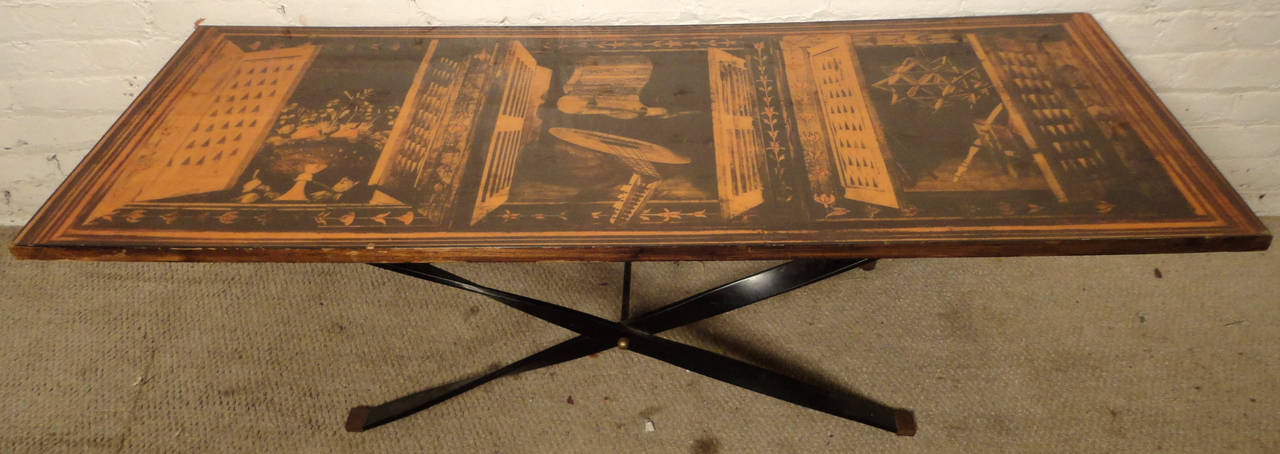Vintage-Couchtisch mit verdrehtem Metall-X-Fuß. Laminatplatte, auf der drei Fensterrahmen mit offenen Fensterläden abgebildet sind. Ein toller Blickpunkt für Ihr Wohnzimmer.

(Bitte bestätigen Sie den Standort des Artikels - NY oder NJ - mit dem