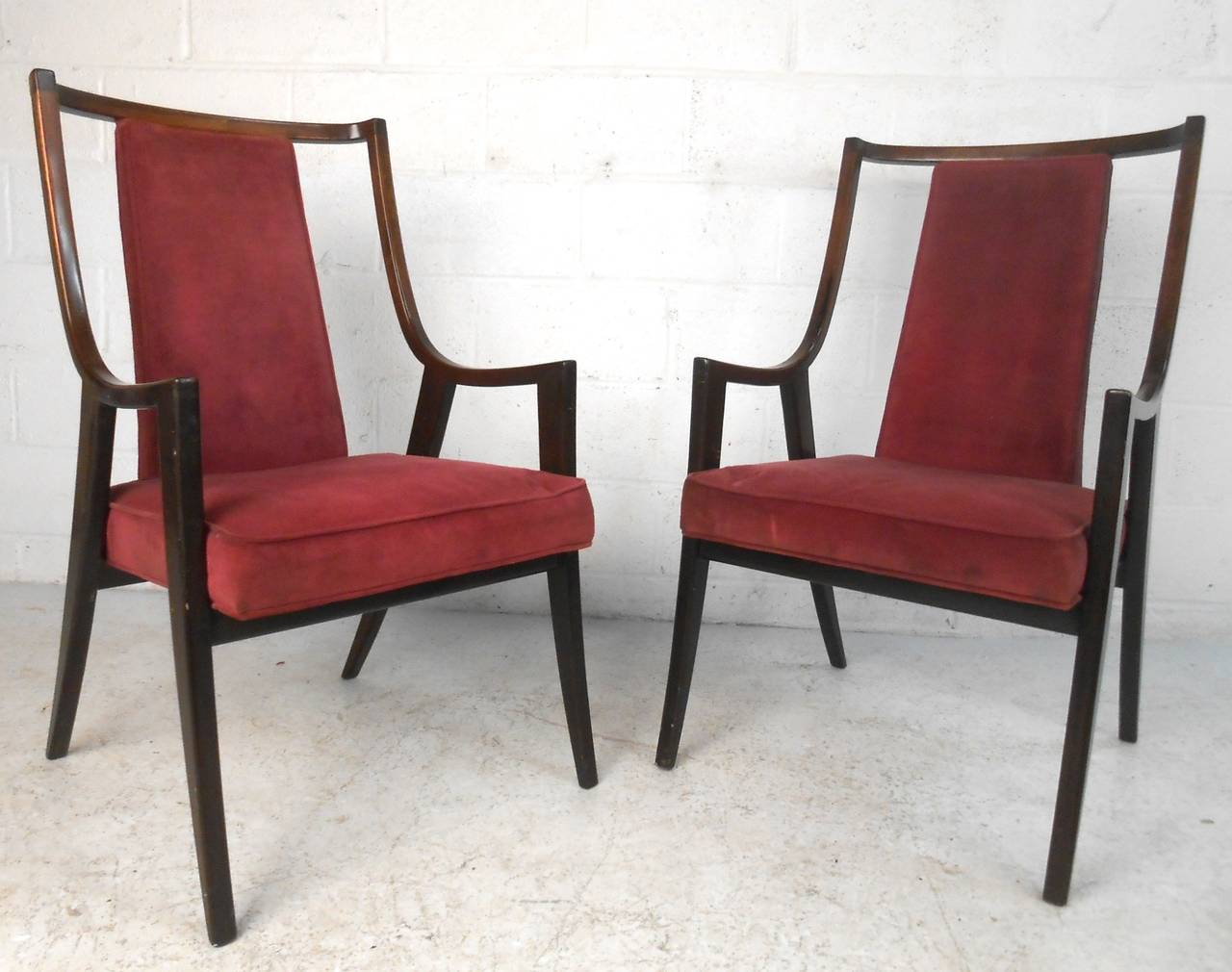 This pair of unique armchairs feature crushed velvet upholstery, comfortable high backs, and wonderfully angled tapered legs in the style of midcentury master Robsjohn-Gibbings. Please confirm item location (NY or NJ).