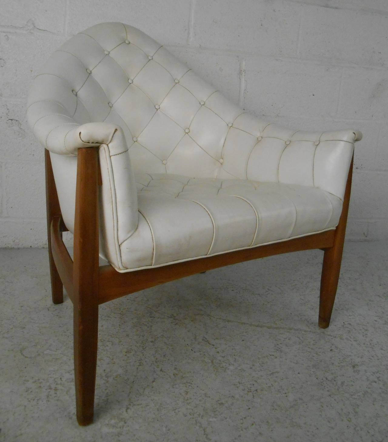 Walnut and tufted leather armchair by Milo Baughman. Please confirm item location (NY or NJ) with dealer.