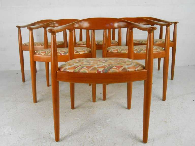 This matching set of twelve dining chairs features Mid-Century Danish design and construction in the style of Hans Wegner. Sculptural hardwood frames offer rounded Horn backs and well-padded seats. This elusive set of twelve is perfect for large