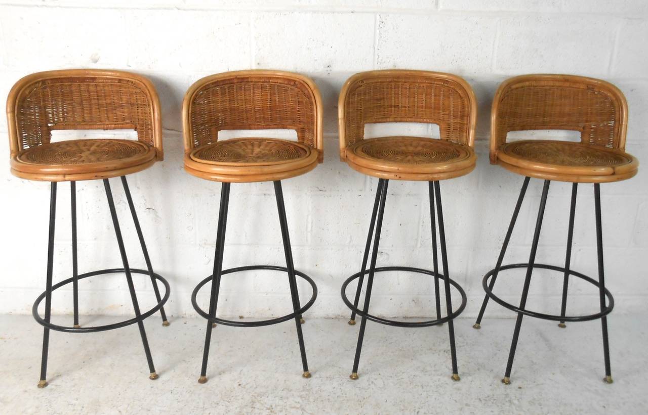 This set of four rattan frame barstools feature sturdy iron frames, basket weave style seat backs, and make a wonderful addition of mid-century style to any setting. Unique design and construction set these Danny Ho Fong style barstools apart from