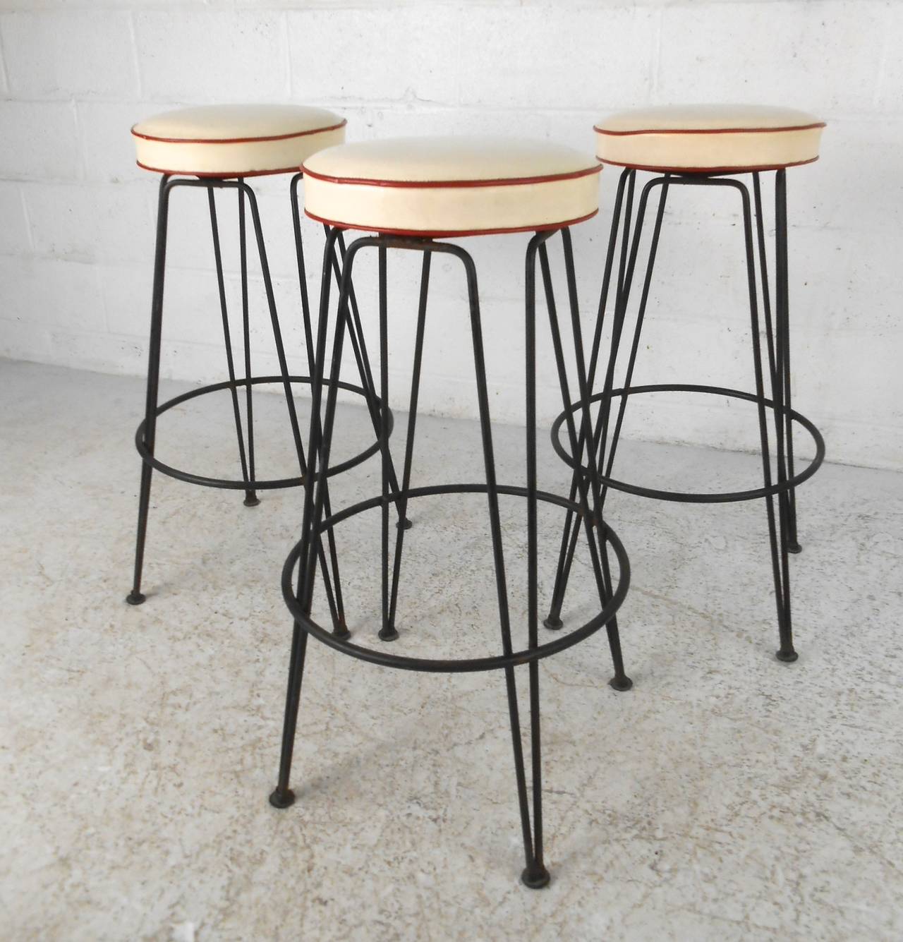 This set of of Mid-Century modern hairpin leg barstools feature intact vintage vinyl seats on sturdy cast iron bases. Swivel seats make these a unique set for any bar setting. Please confirm item location (NY or NJ).
