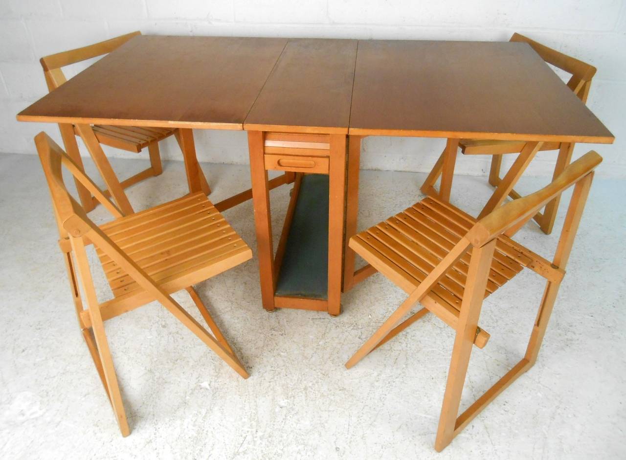 This hideaway dining set makes the perfect addition to homes and businesses in need of space-saving innovation. Four slat chairs tuck safely into the center of this expandable table. Includes sturdy casters and extra drawer for storage, please