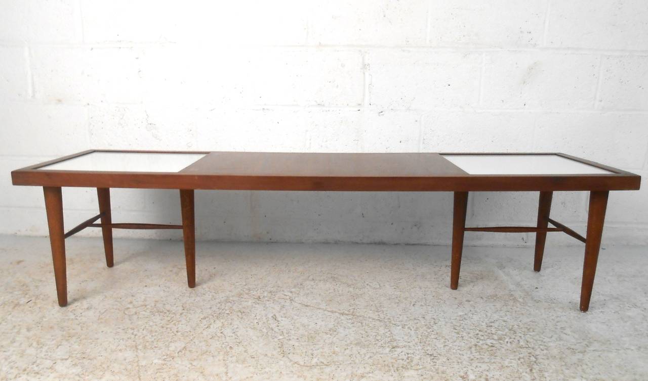 This uniquely long mid century table features white tile inserts complimented by decorative brass star-shaped inlays. Quality walnut construction and a six leg configuration with stretchers provides a sturdy and stable tabletop. Please confirm item