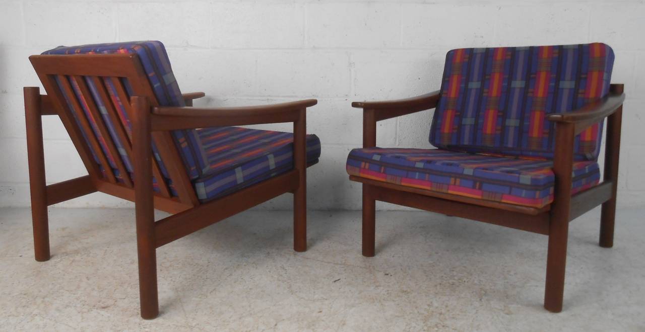 Great pair of comfortable Mid-Century Danish lounge chairs with teak frames and cushioned seats and backs. Please confirm item location (NY or NJ) with dealer.