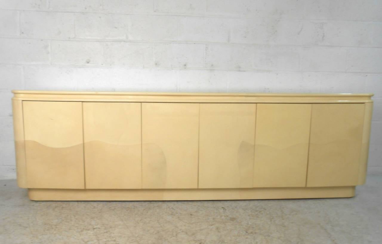 This faux goatskin Springer style server is weighty and substantial. Large size and fantastic Mid-Century style make this a great addition to any interior. Plenty of storage for serving or otherwise housed within three separate cabinets. Please