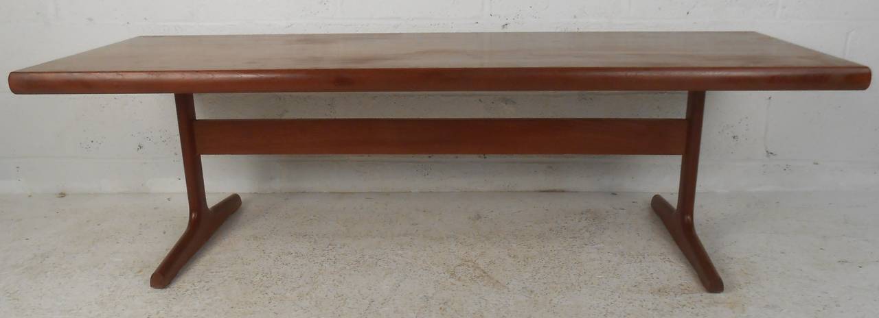 Table basse moderne danoise en teck. Cette table basse élégante et moderne du milieu du siècle est dotée d'un grand plateau rectangulaire et de pieds luge robustes. Le magnifique grain du bois de teck et les bords lisses font de cette table le