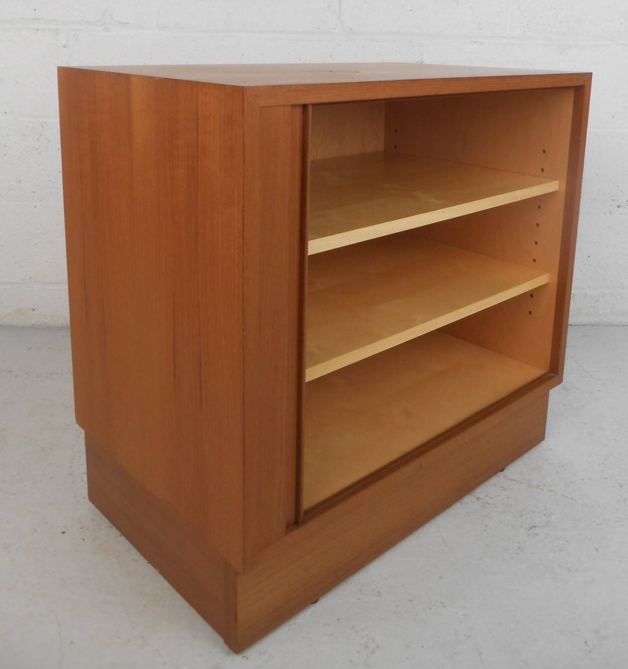 Mid-Century Modern teak storage cabinet with tambour door and two adjustable beech shelves. Danish furniture makers mark. Please confirm item location (NY or NJ) with dealer.