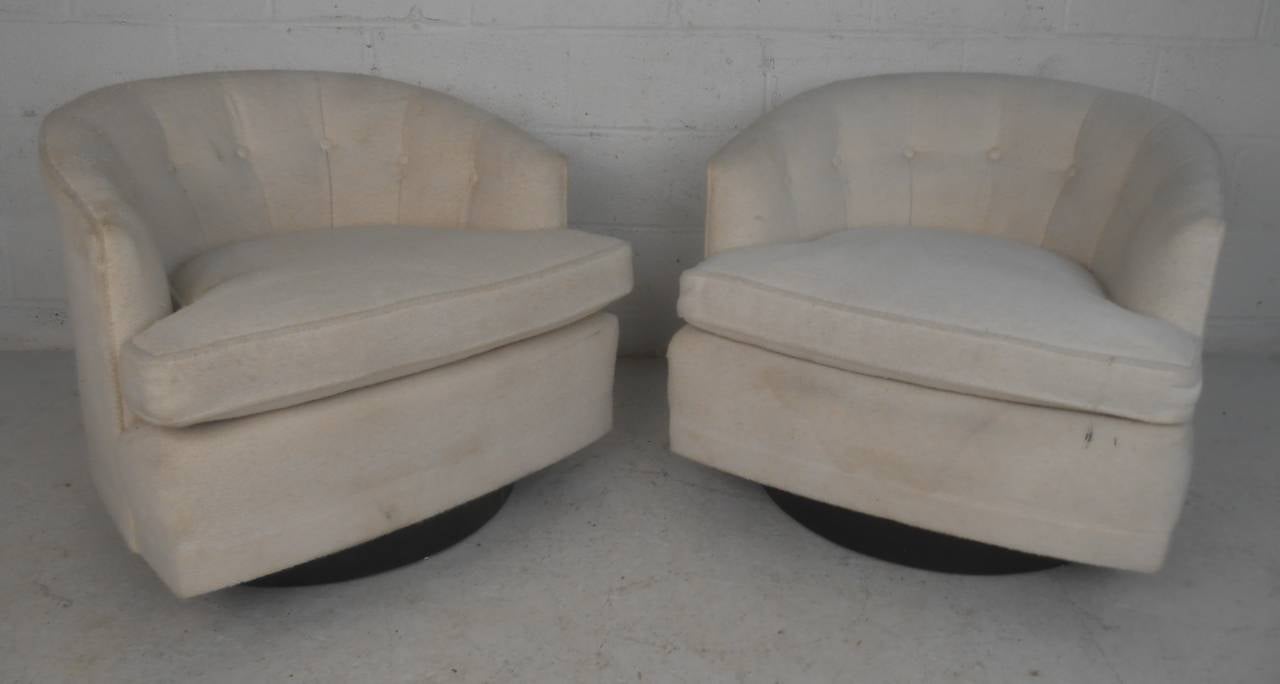 Pair of swivel lounge chairs with black bases, attributed to Milo Baughman. Please confirm item location (NY or NJ) with dealer.