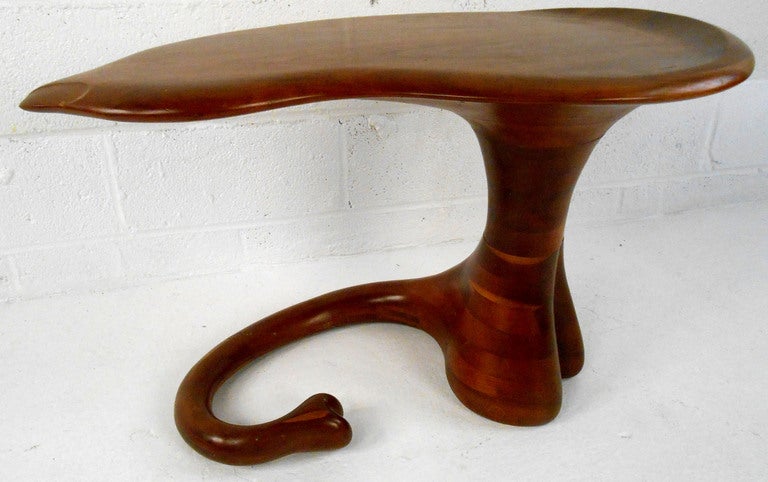 This unique sculptural end table features solid carved wood design by Stewart Paul, tail-like base complimented by live edge swivel top. Impressive accent piece for any midcentury interior. Please confirm item location (NY or NJ).