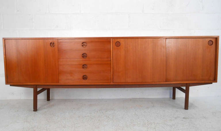 This unusually long Teak server features stylish midcentury style pulls and spacious cabinets for storage. Ideal storage credenza for dining room or office. Please confirm item location (NY or NJ).