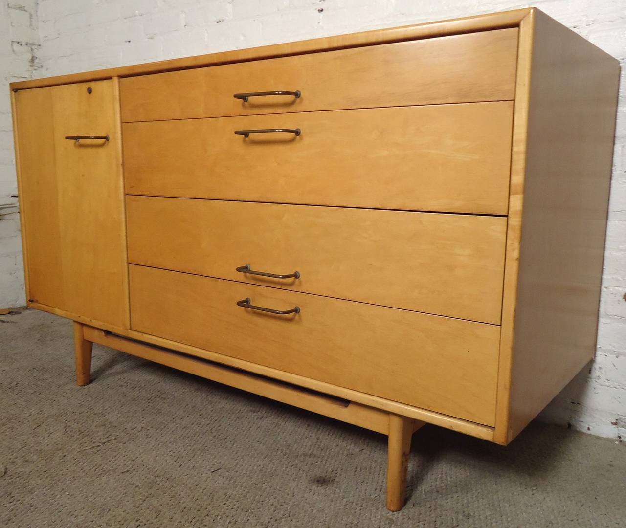 Vintage Jens Risom maple credenza.
One cabinet with adjustable shelf.
Four drawers all with bent brass handles.
Sculpted legs.

(Please confirm item location - NY or NJ - with dealer).