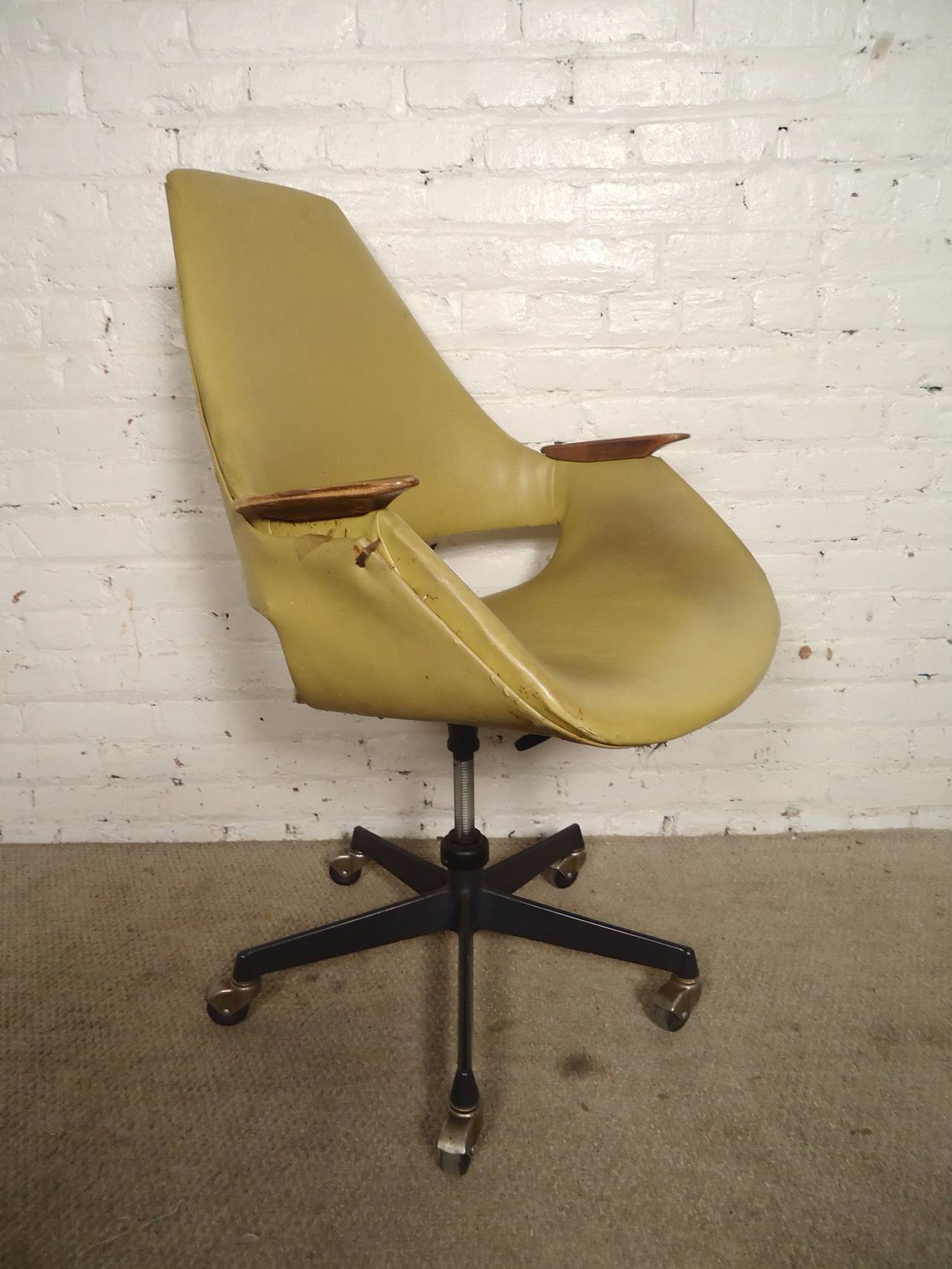 Saarinen style vintage modern chair on rolling casters with adjustable seat. Form fitting body with walnut arm rests. Full vinyl covering throughout the elegant frame.

(Please confirm item location - NY or NJ - with dealer)