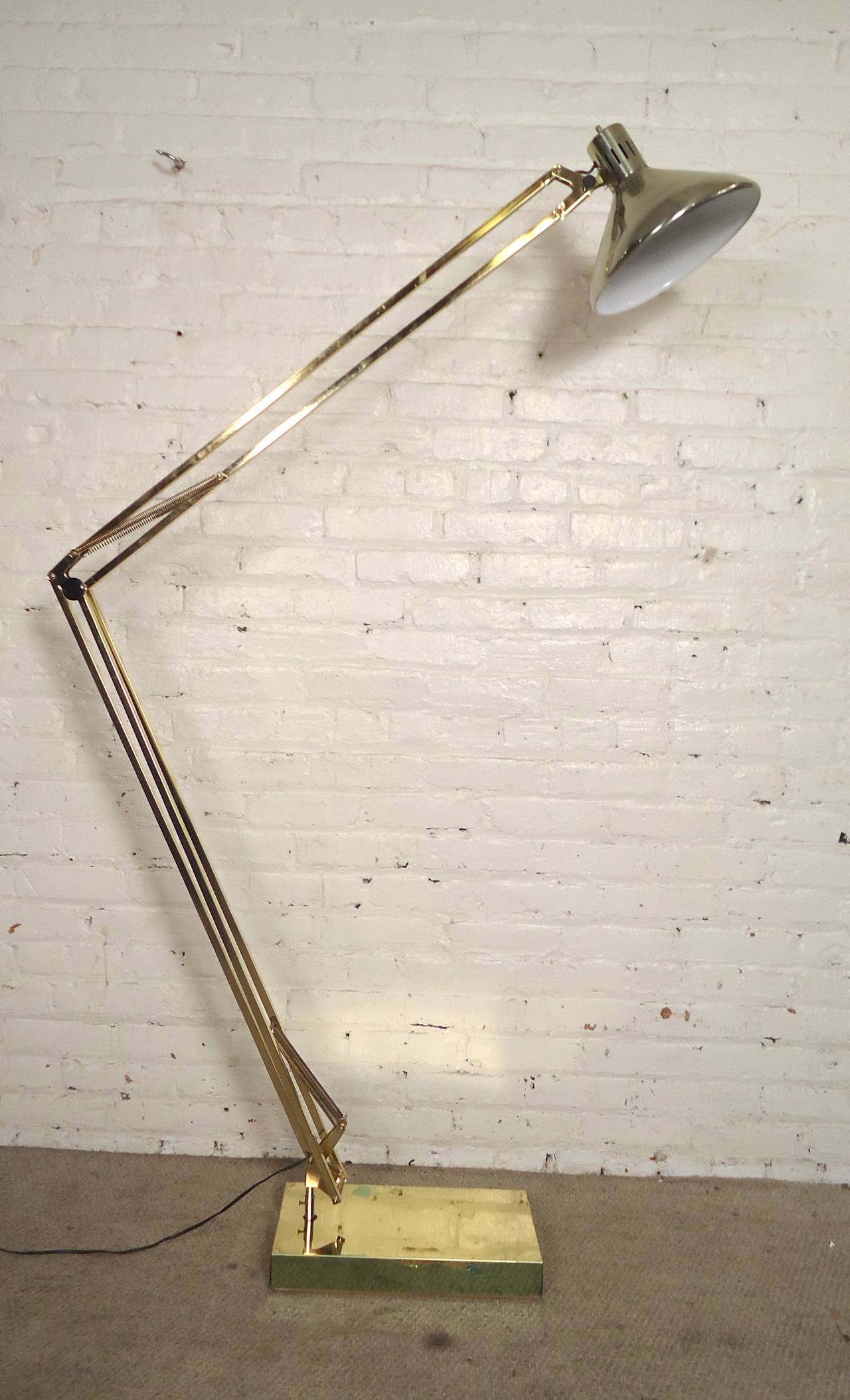 Rare brass floor lamp adjusts from three feet lowered to over six feet high extended. In the manner of the over-sized desk lamps made popular by Gaetano Pesce. Takes one medium size bulb and can turn all the way around to shine in any