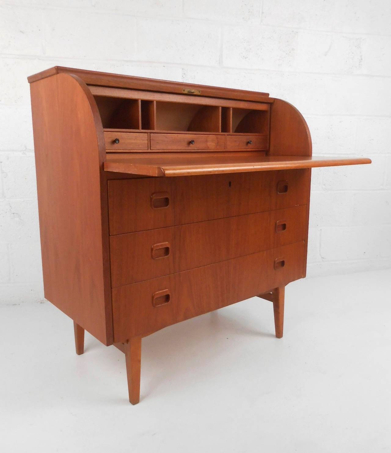 This beautiful teak writing desk offers a wonderful pull out workspace (17.5 x 34) and plenty of options for concealed organization. Unique small size perfect for small spaces, please confirm item location (NY or NJ).