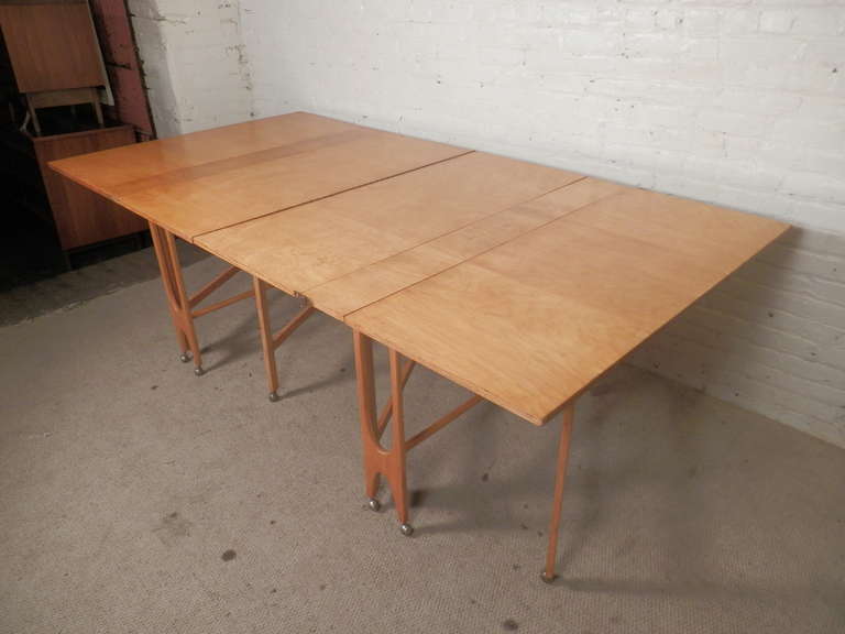 Exquisite blonde maple dining table measuring almost 8 feet long and collapsing neatly to just 16 inches wide. Rolling casters make for easy moving and storage.

Measure: 16-93