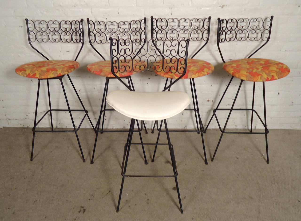 Set of five metal stools designed by John Salterini. Strong wrought iron with decorative back. Swivel seats, foot rest, hair pin legs. 

(Please confirm item location - NY or NJ - with dealer)