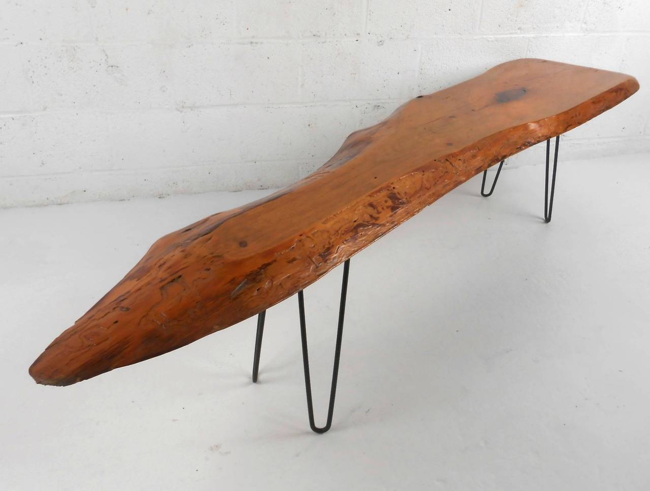 This unique freeform coffee table makes a wonderful addition any rustic or modern interior. Stylish hairpin legs compliment this unique slab top table, signed by creator but illegible. This lovely mid-century live edge coffee table makes the perfect