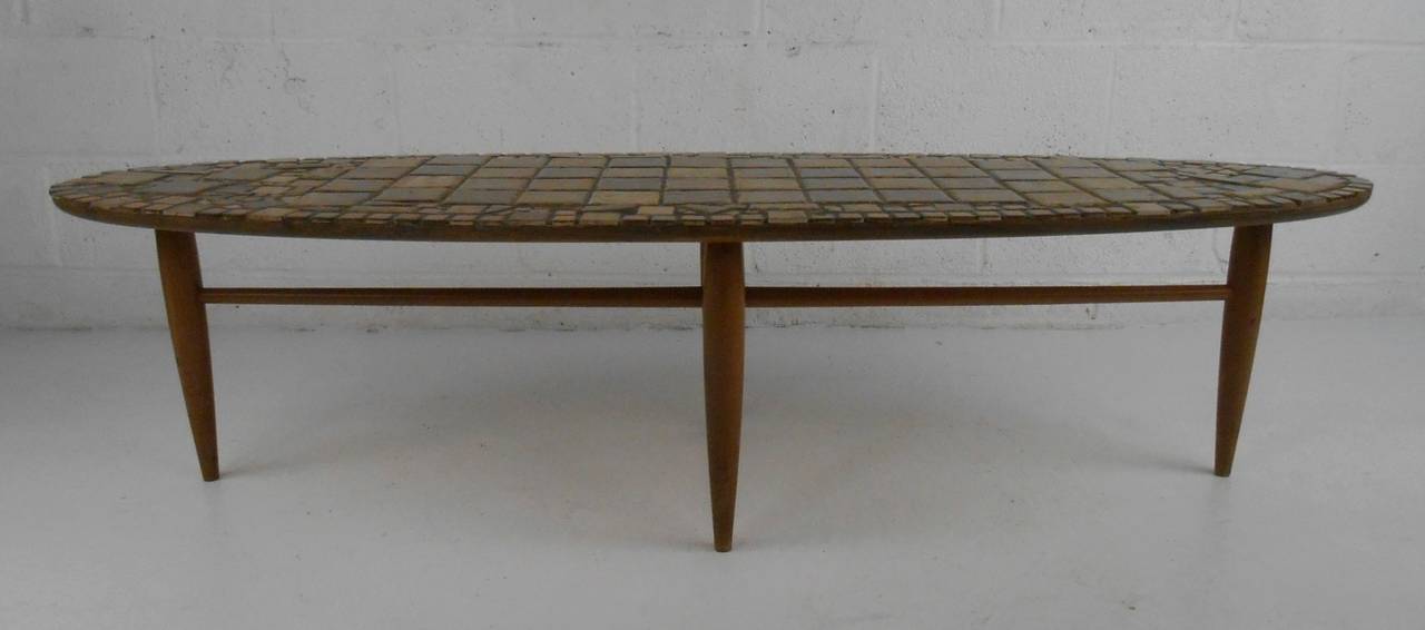 Tile top coffee table, surfboard style, manufactured by Mersman, Celina, Ohio. Stylish and substantial cocktail table with unique stone tile top adds distinctive mid-century style, perfect for home or office sofa seating area. Please confirm item