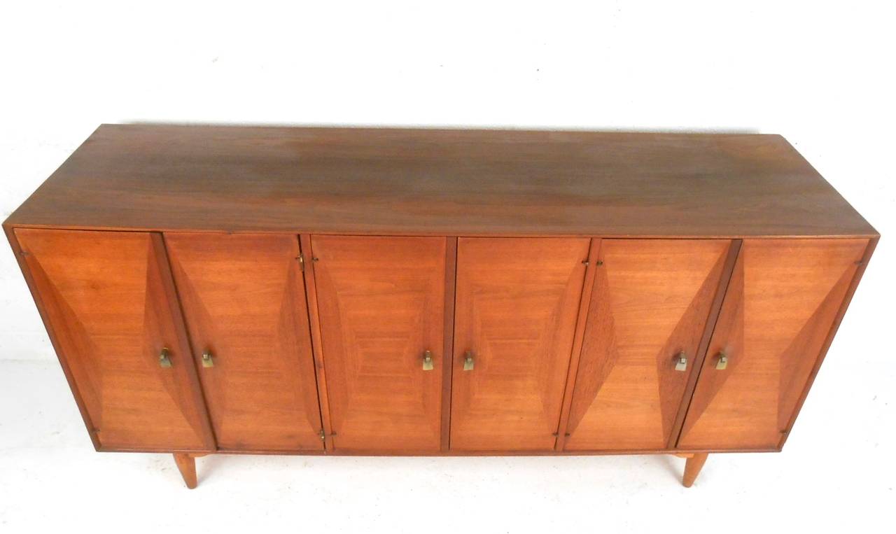 This unique vintage server by Ramseur furniture features beautiful multi-directional veneer on cabinet doors, as well as unique mid-century pulls. Plenty of storage in dual cabinets and an extra set of center drawers. Please confirm item location