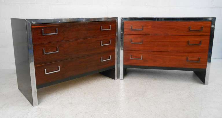 Impressive pair of rosewood and chrome trim dressers feature spacious drawers for storage, and make an ideal pair of oversized bedside tables or standalone dressers. Black lacquer finish adds to the Mid-Century Modern appeal of the two. lease