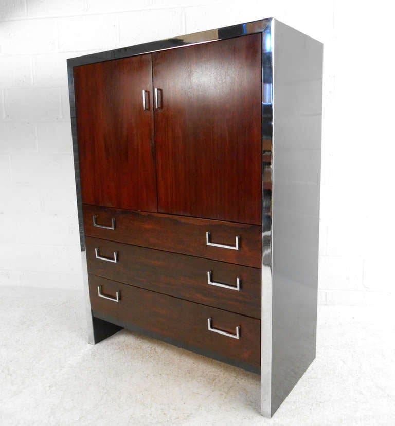 This mid-century modern gentleman's chest features beautiful rosewood, accented by modern chrome handles and trim. Please confirm item location (NY or NJ) with dealer.