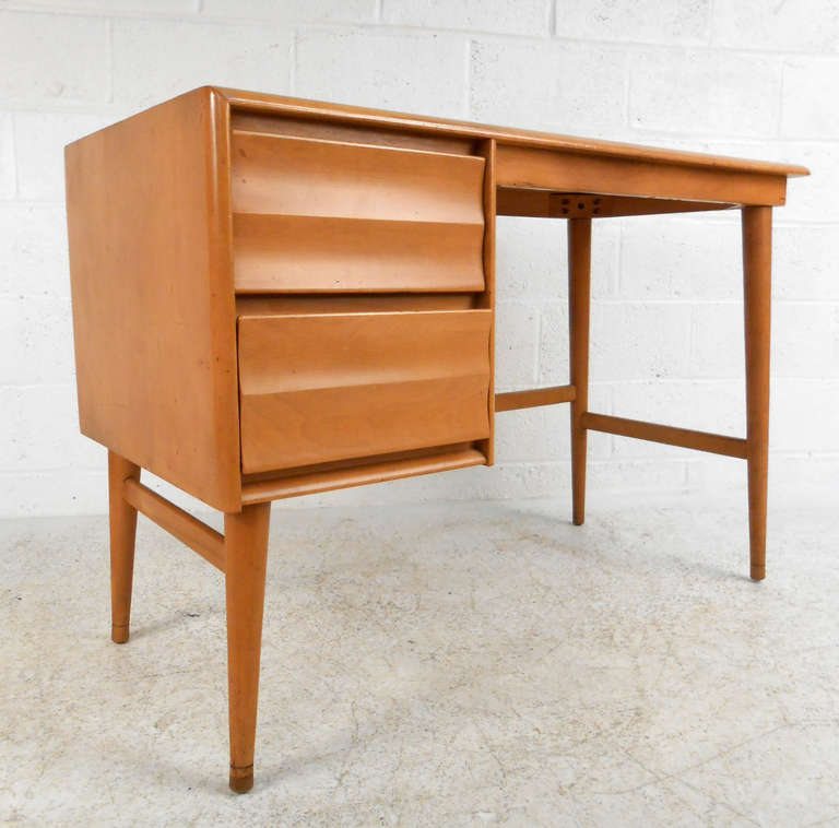 This compact, mid-century student desk by Heywood Wakefield is made of solid maple with a champagne-toned finish.  Please confirm this items location (NY or NJ).
