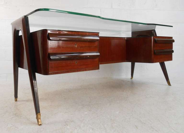 Exquisite rosewood desk created in the style of Milanese designer Paolo Buffa.. Featuring Brazilian rosewood veneer,  four drawers, glass top and brass sabots. 

Please confirm item location (NY or NJ) with dealer.