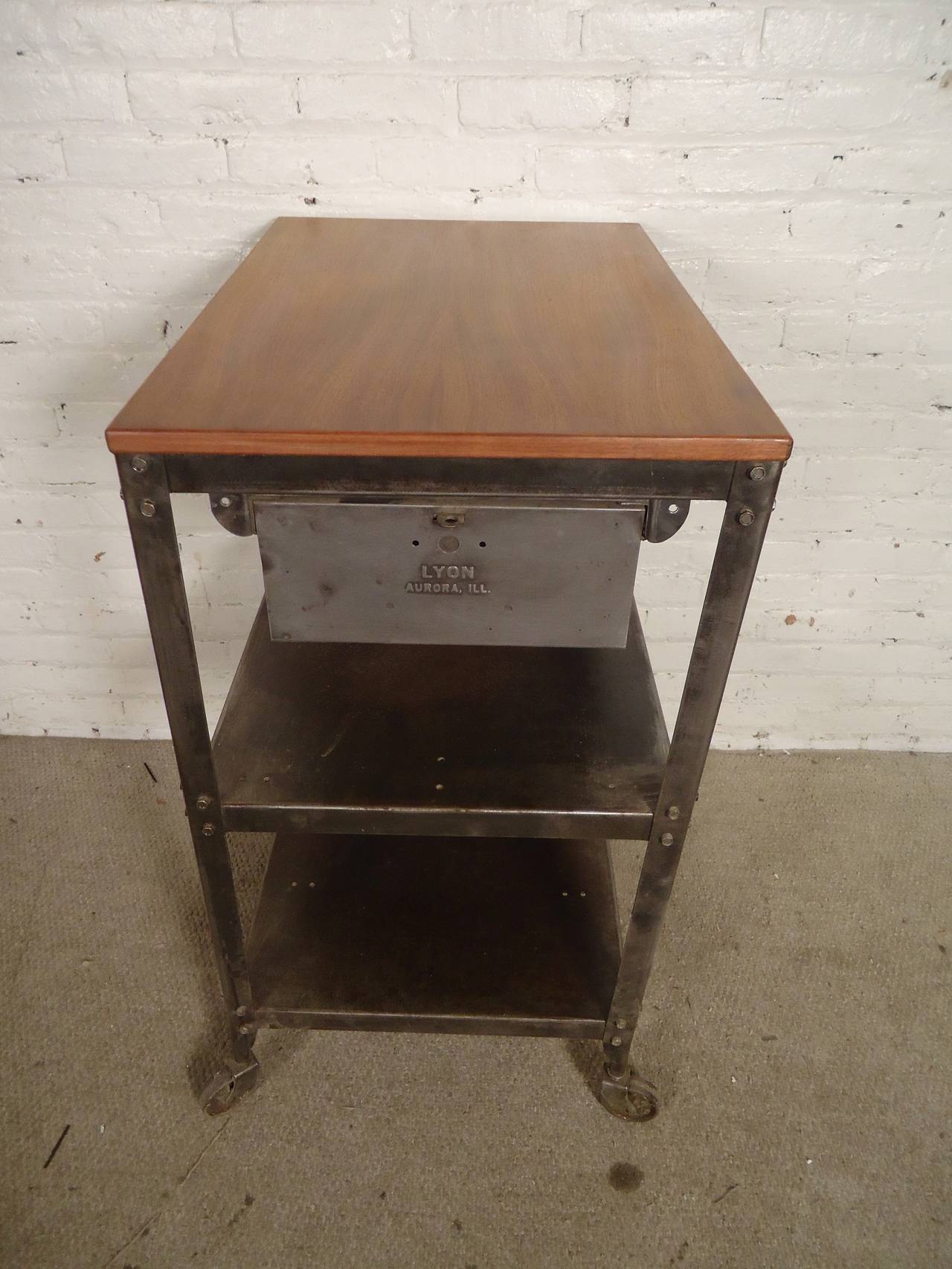 Heavy industrial metal factory cart made by Lyon, with rolling casters, large drawer and teak wood top. Newly restored in a bare metal style finish. 

(Please confirm item location - NY or NJ - with dealer)