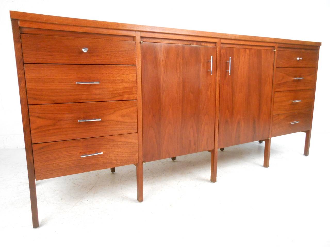 This mixed wood dresser designed by Paul McCobb for Lane Furniture features a stunning mix of storage options in solid Rosewood & Walnut construction. Unique pulls, extra legs for stability, and a wonderful wood grain make this a fantastic addition