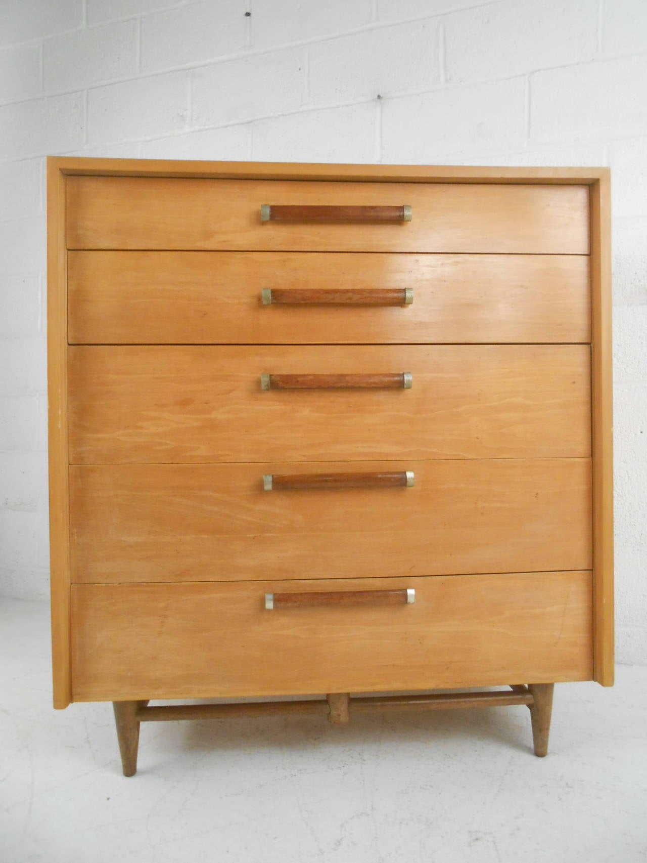 This unique and well constructed mid-century Maple dresser features wonderful details including tapered legs with added stretchers and unique drawer pulls. Matching low dresser available, wonderful piece for any modern interior. Please confirm item