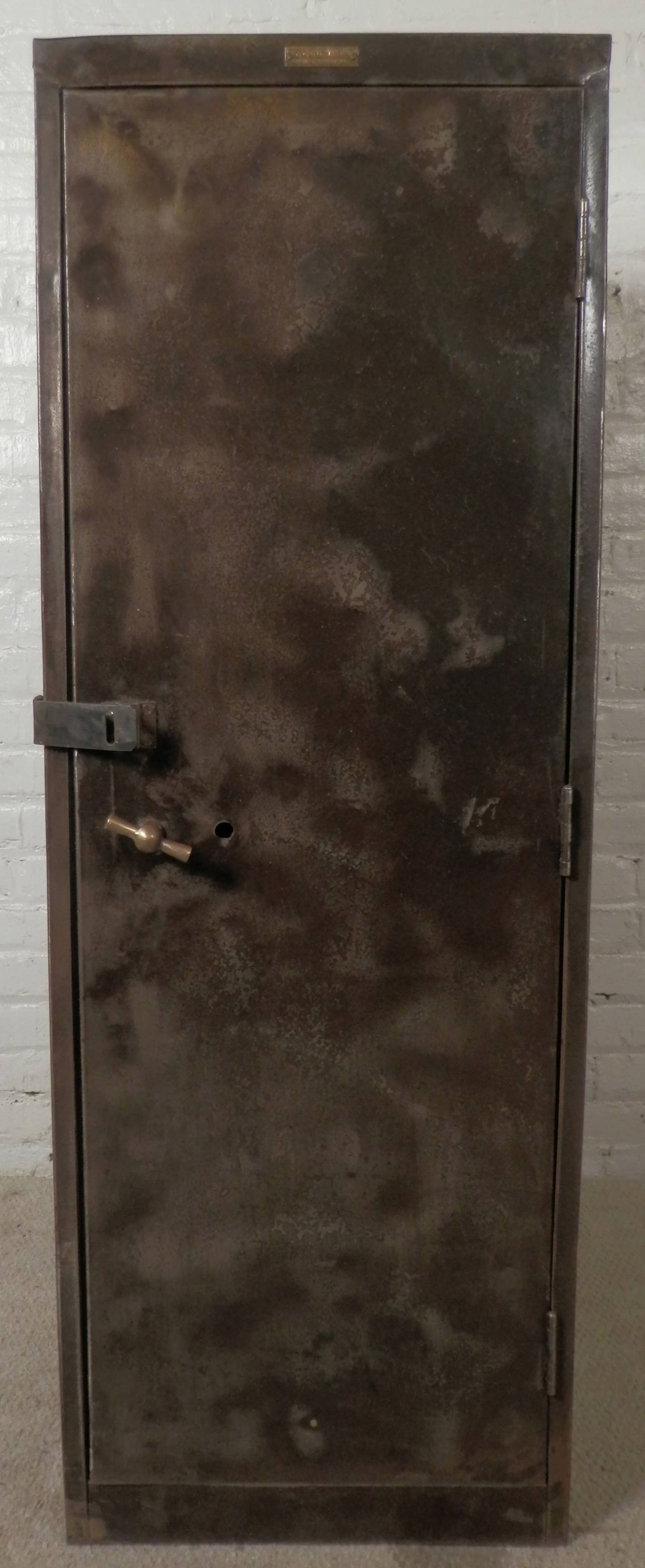 Industrial cabinet featuring one large door with latch and brass handle, interior includes three metal shelves. Huge vintage bank safe style, with great wear that adds character. 

(Please confirm item location - NY or NJ - with dealer)