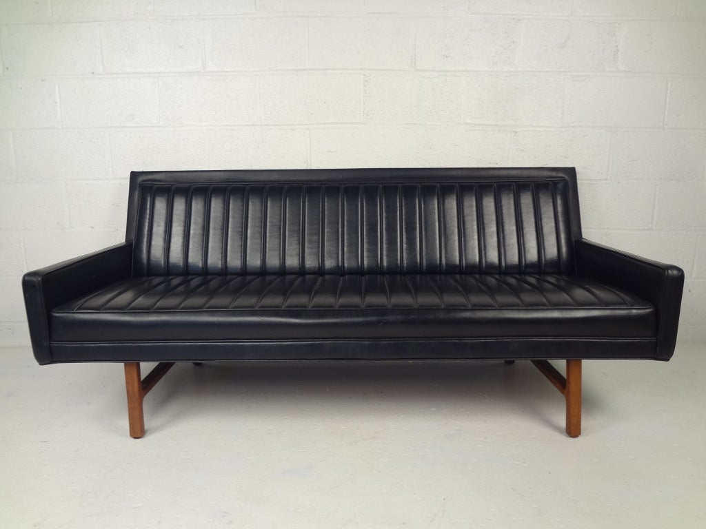 Black leatherette sofa with walnut legs designed by Milo Baughman.