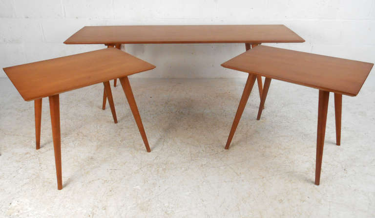This vintage set of end tables with matching coffee table features a wonderful maple finish and tapered legs in the style of Paul McCobb. Lovely original finish, perfect for home or office. Please confirm item location (NY or NJ).