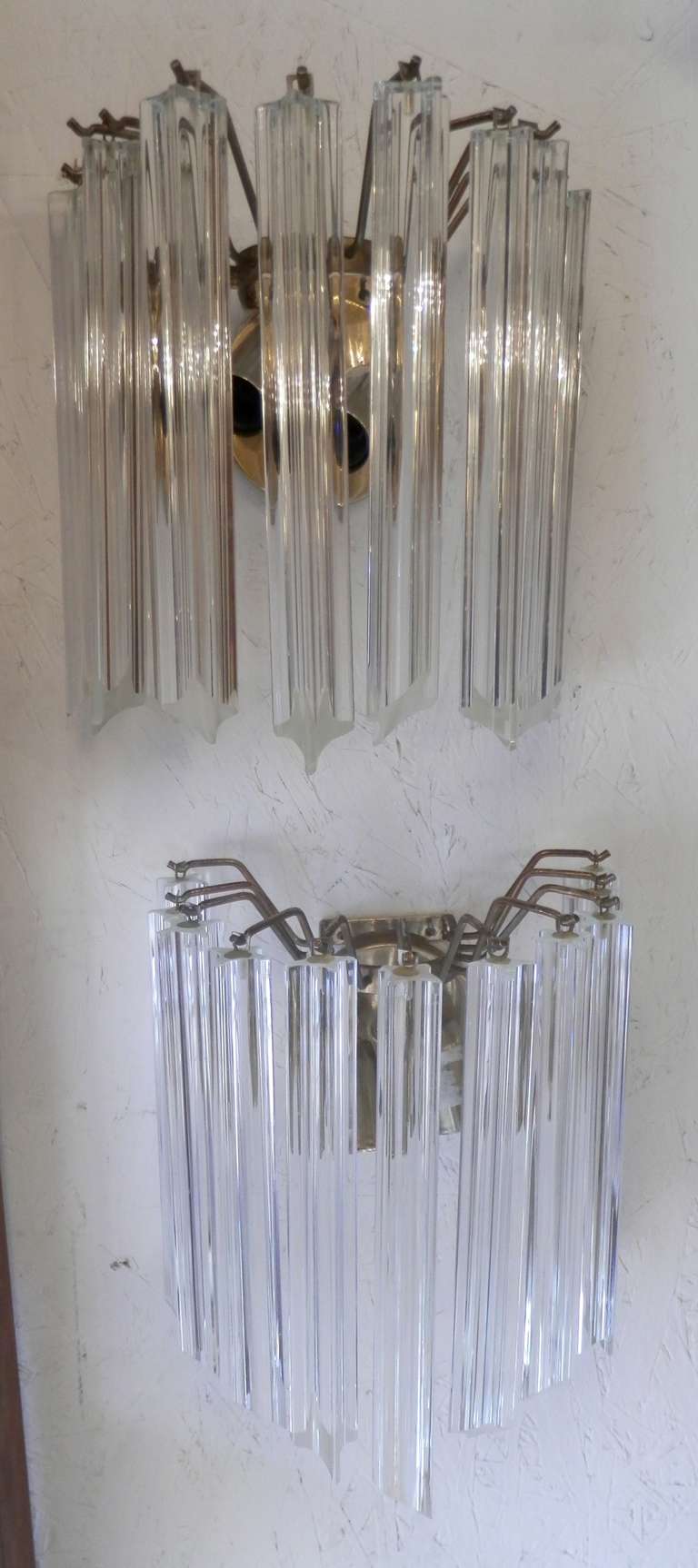 Pair of wall mounted hanging glass chandelier-style sconces with brass fitting. Takes two bulbs each with adjustable heads, wrapped in Murano style prism glass. In the style of Camer made glass sconces, but not tagged.

(Please confirm item