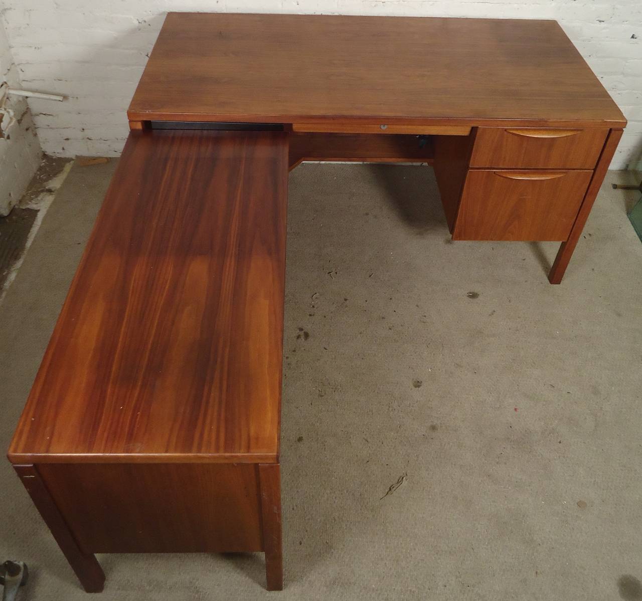 Striking L-shaped desk by Jens Risom with finished back. Walnut grain throughout, multi-size file drawers, sculpted handles.
Desk connects with underside locking mechanism.

(Please confirm item location - NY or NJ - with dealer).