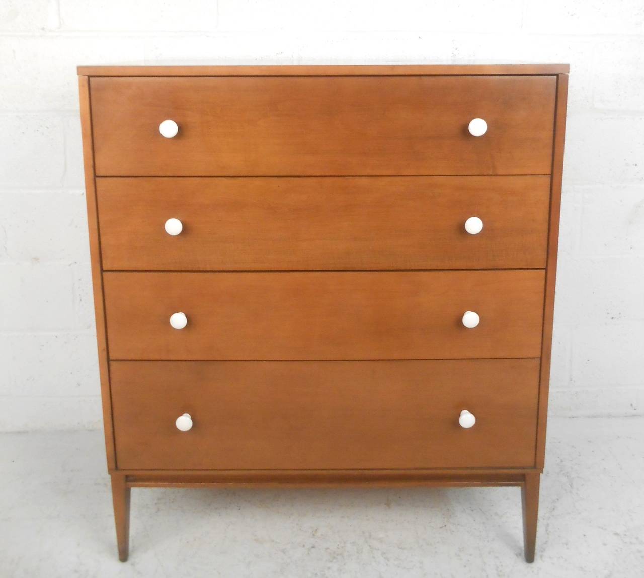 This Paul McCobb dresser has had it's original drawer pulls replaced, but still provides a wonderful example of his influential midcentury design. Features tapered legs and sturdy construction, please confirm item location (NY or NJ).