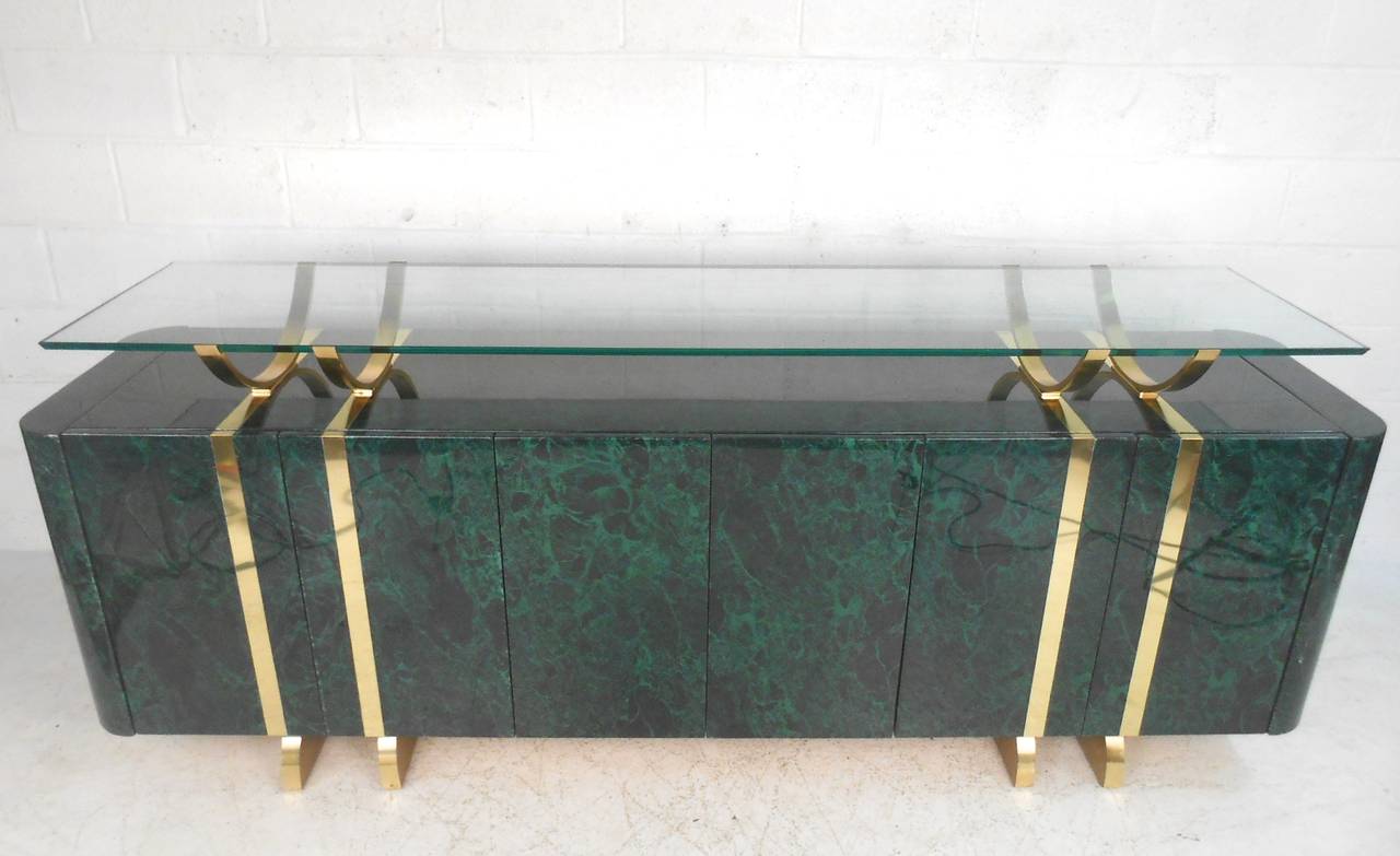 The unique marbleized finish on this large server is perfectly complimented by exquisite brass trim and unique beveled glass floating top. Ideal for serving, display, and storage, this wonderful piece makes a unique addition to any interior. Please